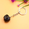 Llavero de piedra de cristal negro envuelto en alambre de cobre sobre fondo naranja - Ágata negra