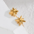 Macro shot of minimalist gold star stud earrings resting on a white textured stone surface - Octagonal Star (E887-bmx)