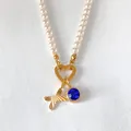 Collier de perles raffiné avec pendentif lettre A dorée et charmant cristal bleu vif - Lettre X