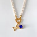Exquisite pearl necklace featuring a gold letter A pendant and a shiny blue crystal charm - Letter X