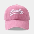Gros plan de la broderie Brooklyn blanche sur le coton rose délavé de la casquette - Réglable / Rose