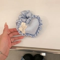 Detailansicht eines hellblauen herzförmigen Haargummis mit Rüschen und Schleife - Blaues Herz