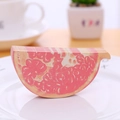 3D grapefruit shaped sticky notes in pink fruit design placed on a white ceramic plate - Pomegranate