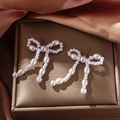 Elegantes pendientes de perlas con forma de lazo y borlas en una bandeja dorada - 0689-Pendientes Colgantes con Lazo y Borla