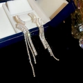 Details von geometrischen Quasten-Ohrringen in Warmgold mit weißen Zirkonia im Wellen-Design - Gold