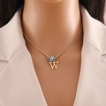 Detail of twisted gold chain with blue evil eye bead and letter W pendant on a model - Letter W (N1339)