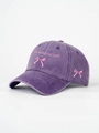 Detail of pink bow embroidery and 'I'm literally just a girl' text on a purple washed cap - Dark Purple