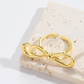 Macro-opname van gouden strikring op beige steen met een retro verstelbare open band - Knoop Stijl (JZ0460-3)