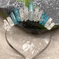 Close-up of triple moon crown featuring clear and blue raw crystals on mossy stone - White & Blue Patchwork Crystal with Triple Moon