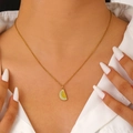 Detail view of a gold watermelon slice pendant necklace worn by a model in a white shirt - Colorful Watermelon Style (DZ-511)