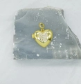 Detail showing a heart-shaped gold pendant with butterfly zircon inlay on rock background - Butterfly Heart