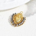 Macro shot of gold heart pendant with beaded trim and blue faceted accents on white base - Gray Blue Beads/Gold
