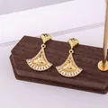 Elegant gold fan-shaped earrings with tiered zircon stones on a wooden display - Fan-Shaped Rhombic Pattern / E-075---Gold