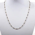 Detail view of a gold-plated stainless steel bead chain with black enamel beads on a model - Gold + Black