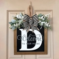 Wooden door sign featuring letter D with black bow and greenery on beige door - Letter D