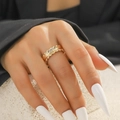 Detail eines unregelmäßigen goldfarbenen Wellenrings mit Hammerschlag-Struktur am Finger - Goldene Welle gehämmert