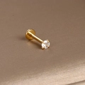 Macro-opname van goudkleurige labret piercing van roestvrij staal met een zirkonsteen - Gouden Vierklauw Zirkonia Stijl 2