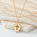 Macro detail of vintage gold cross pendant with black zircon on an oval necklace medal - Oval Black Zirconia Cross