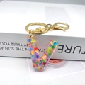Macro detail of alphabet V resin keychain with colorful heart sequins and gold hardware - Letter V Lobster Clasp Keychain