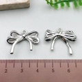 Silver bow-shaped metal pendants measured on a ruler for DIY jewelry making - Double Layer Hollow Bowknot - Silver (21407)