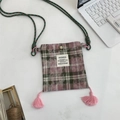 Close-up of vintage plaid crossbody phone bag with fringe tassels and magnetic snap - Pink