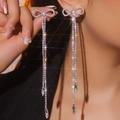 Elegant silver tassel earrings with crystal bow and water drop pendants in a hand-held view - Silver Bowknot Tassel Waterdrop Drop Earrings DTE1816378S