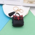 Black leather owl keychain with red eye accents, golden hardware and a matching tassel - Black