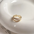 Close-up of double-layered gold ring with zircon squares and wavy band on ceramic plate - Ripple Double Layer