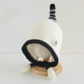 Detail van baby winter gebreide muts met zachte fleecevoering en leuke pinguïn patch - 54cm (3-8 jaar) / Wit