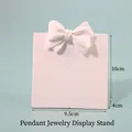 White resin jewelry display stand with bow detail showing 9.5cm x 10cm dimensions - Small Bowknot Necklace Stand
