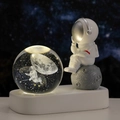 Luce notturna a sfera di cristallo astronauta con base a LED calda su sfondo cielo stellato - Passeggiata Spaziale