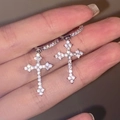 Orecchini a croce gotici in argento con diamanti, tenuti in mano per visualizzazione - Argento (M-091)