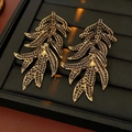 Dettaglio di orecchini vintage a foglia con strass scuri su un vassoio da esposizione - Oro Nero (Perno in Argento)