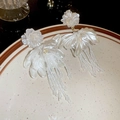 Detail of white flower earrings with long beaded tassels and mother-of-pearl sheen on a plate - White Pearlescent Petal Tassel