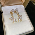 Détail de boucles d'oreilles perles avec chaîne strass et pendentifs pétales blancs - Or / Doré