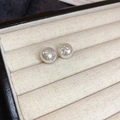 Dettaglio ravvicinato di orecchini di perle con fiocco su un vassoio di velluto beige - Stile Perla e Fiocco / Orecchini di perle con fiocco bianco (ago d'argento)