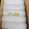 Macro shot of natural citrine raw stone stud earrings with gold four-prong setting - Citrine