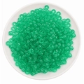 Bulk stack of transparent green acrylic barrel beads with large holes in a white tray - 100 Pieces/Pack (9x6mm) / Dark Green