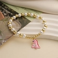 Bracelet mignon perles blanches et dorées avec un pendentif dinosaure en émail rose - Dinosaure Rose