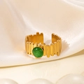 Detalle de un anillo vintage de titanio chapado en oro de 18K con gema verde sobre seda crema - Estilo de Piedra Ojo de Gato Verde (R0849)