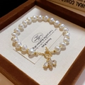 Dettaglio di un bracciale di perle multistrato con ciondolo a ape dorata e zirconi brillanti - 29# Bracciale con chiusura a T in perle d'api