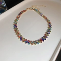 Detail van een kleurrijke strass-choker met goudkleurige basis en verstelbare ketting - Kleurrijk