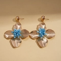Close-up of vintage gold floral earrings with radial textures and blue textured centers - Flower Shape Silver Pin Earrings / Blue