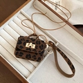 Détail macro du mini pendentif sac en cuir léopard avec fermoir doré et anneau métallique - Collier / Café Foncé