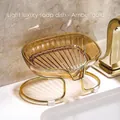 Amber gold resin soap dish with gold metal stand on a marble bathroom counter - Amber
