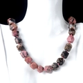 Knotted natural stone necklace with pink and black faceted geometric beads on model - Rhodonite