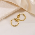 Dettaglio di orecchini a cerchio dorati con nodo su marmo bianco e seta elegante - Oro