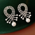 Vista macro degli orecchini in argento con zirconi e perle su velluto verde scuro - Argento & Bianco (Silver Earring Post)