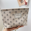 Beige corduroy makeup bag with black cartoon rabbit patterns and a central label - Milk White Rabbit