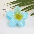 Detail of light blue plumeria hair claw clip with yellow gradient and resin texture - Blue Flower